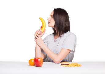 picture of woman with fruits and hamburger in front on white bac