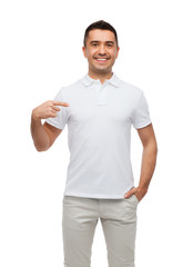 smiling man in t-shirt pointing finger on himself