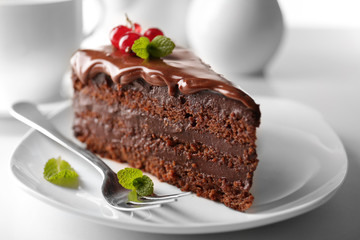 Wall Mural - Delicious chocolate cake on plate on table on light background