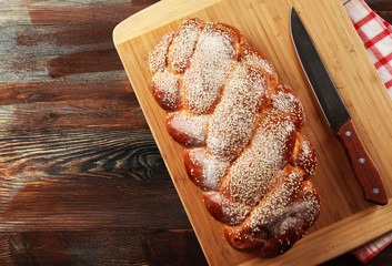 Poster - Fresh bun on cutting board on wooden table close up