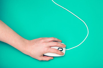 hand on computer mouse, emerald background