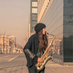 Beautiful young woman playing tenor saxophone