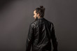 © vladimirfloyd - back view of man with beard and bun in black leather jacket