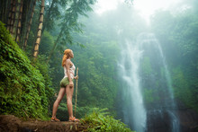 Female adventurer looking at waterfall