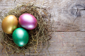 Easter decorations. Eggs in nests on wooden background