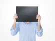 © Dave_Pot - young man hiding his face behind an empty blackboard