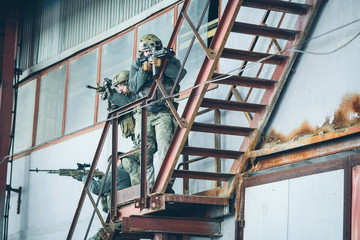 Wall Mural - three soldiers climb the stairs at the factory