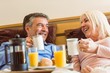 © WavebreakMediaMicro - Happy mature couple having breakfast in bed