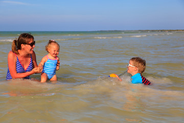 mother with two kids swimming at the sea