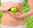© chettythomas - Slim woman in white underwear with green apple at her hands over