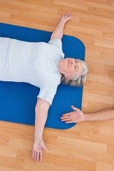 Wall Mural - Senior woman lying on exercise mat