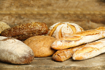 Wall Mural - Different fresh bread on old wooden table