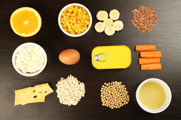 Various food products containing vitamins on wooden background