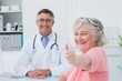© WavebreakMediaMicro - Patient showing thumbs up sign while sitting with doctor