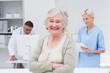 © WavebreakmediaMicro - Patient smiling while doctor and nurse working in background