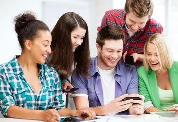 Wall Mural - students looking at smartphone at school
