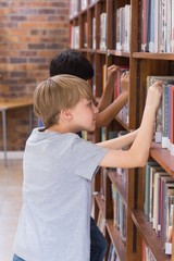 Wall Mural - Cute pupils looking for books in library