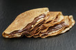 thin crepes or blinis with chocolate cream on slate board
