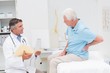 © WavebreakMediaMicro - Doctor discussing reports with patient suffering from back pain