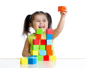 child plays with building blocks and shows red cube