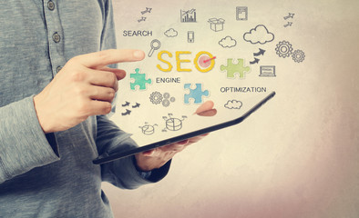 Sticker - Young man pointing at SEO concept over a tablet