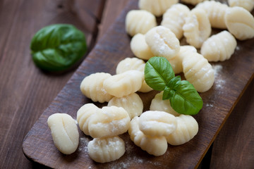 Wall Mural - Rustic chopping board with raw gnocchi, studio shot, close-up