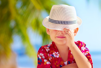 Wall Mural - cute kid boy hiding his face behind hat