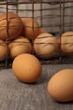 Fototapeta Kwiaty - Brown eggs on a rustic wooden background. Selective focus.