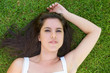 © mimagephotos - Young woman lying on green grass