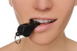 woman holding whistle in his mouth closeup