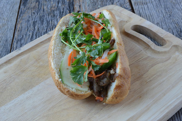 Wall Mural - Vietnamese Grilled Pork Banh Mi Sandwich on Rustic Wood Backgrou