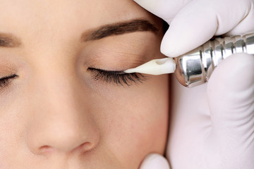 Cosmetologist making permanent makeup, close up