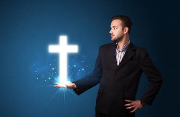 Wall Mural - Glowing cross in the hand of a businessman