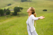 woman with arms outstretched in countryside