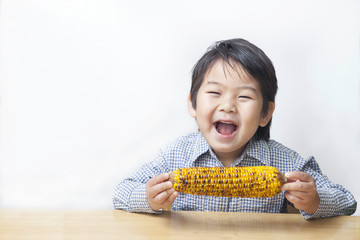 トウモロコシを食べる子供