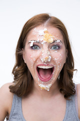 Wall Mural - Laughing young woman with cake on her face