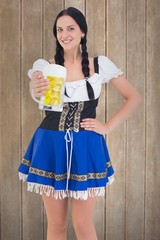 Wall Mural - Composite image of pretty oktoberfest girl holding beer tankard