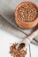 Wall Mural - buckwheat in a wooden bowl on white background