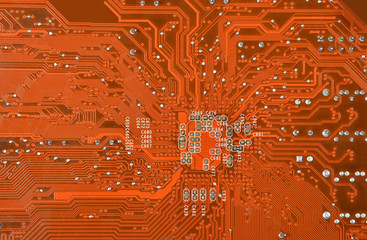 close up of a printed orange computer circuit board