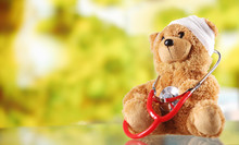 Sick Teddy Bear With Stethoscope On Glass Table