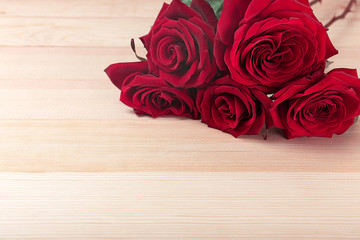 Wall Mural - Beautiful roses on wooden table background