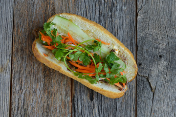 Wall Mural - Vietnamese Grilled Pork Banh Mi Sandwich on Rustic Wood Backgrou