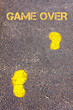 Yellow footsteps on sidewalk towards Game Over message