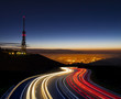 © poliki - car lights at night towards the city and communications antenna