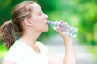© mr.markin - Woman drinking cold mineral water from a bottle after fitness ex