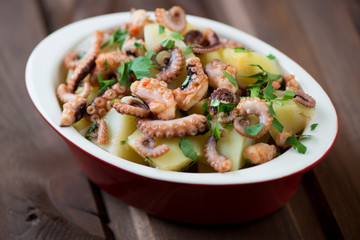 Wall Mural - Octopus salad in a glass bowl, close-up, selective focus