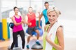 © WavebreakmediaMicro - Portrait of happy woman holding towel at gym