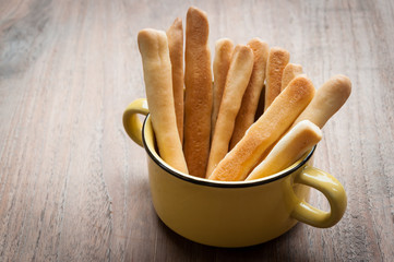 Wall Mural - Breadsticks in napkin on wooden background.