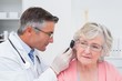 © WavebreakMediaMicro - Doctor examining female patients ear with otoscope