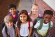 © WavebreakMediaMicro - Smiling little school mixed race kids in school corridor